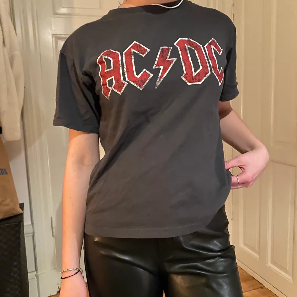 Grå t-shirt med snyggt AC/DC tryck!. T-shirts.