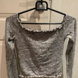 Snygg, grå off-shoulder top från Hollister.  Använd fåtal gånger. Finns i Vällingby men kan skickas med post mot porto.