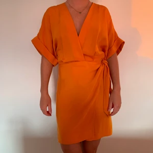 Orange klänning  - Modern omlottklänning från &other stories i storlek 32. Väldigt snygg till både vardag och fest, sommar och höst. Sitter väldigt fint på och färgen är magisk✨ Endast provad, därav nyskick. Nypris: 790kr säljes för 500kr + frakt