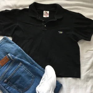 Svart piké från diesel vintage - Svart vintage piké från märket diesel (äkta) har klippt av den lite men köparen får sedan klippa av den till önskad längd då den föredras croppad:) självklart behöver man inte klippa av den mer om man inte vill.