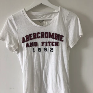 Vit Abercrombie T-shirt strl S - Vit T-shirt från Abercrombie med Tryck. Använd ett fåtal gånger, i fint skick✨ 70 kr + frakt