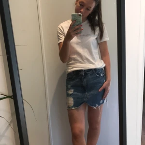 Jeanskjol - Snygg kjol med slitningar från Zara. Endast använd ett fåtal gånger, så den är som ny! Det är en bra längd på kjolen, jag som bär den är 161 CM. 100 kr + frakt 