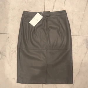 NY Vila kjol XS  - Helt ny kjol i grå skinnimitation (med prislapp kvar) frakt tillkommer 50kr