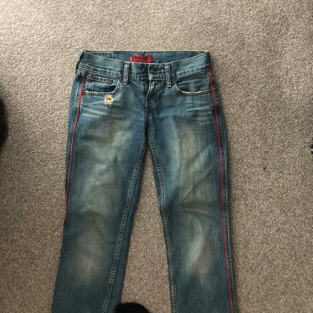 Ett par coola o trendiga ljusblå lågmidjade levisjeans med en röd rand på sidorna. Är w24/xs och är rätt långa på mig (är 163). Så fina och köpta här på Plick men passade inte riktigt och har får många jeans så måste sälja!. Jeans & Byxor.