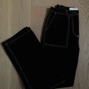  - Svarta byxor med vita sömmar från Junkyard. Knappt använda och säljs pga att de aldrig används av mig. Frakt tillkommer:)