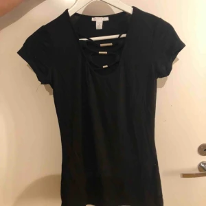  - Svart t-shirt med fina silverdetaljer som använts en gång.