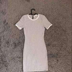 Grå ribbat klänning med vita detaljer för 190 kr ink frakt. 