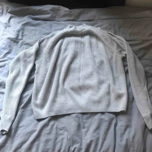  - Grå stickad tröja från H&M, ish halterneck. Plus två styckna hål i varje arm