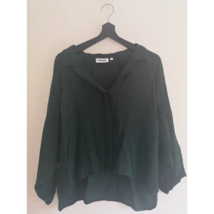  - Mörkgrön skjorta från WEEKDAY. Lite kortare modell. 100% viskos. Fint skick! Ta 3 betala för 2 gäller på allt, billigaste på köpet✨ Övrig generell info om hur jag säljer: läs min profil.  