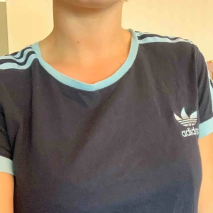  - Mörkblå adidas original t-shirt med ljusblå stripes. Storlek 38 men passar även en s