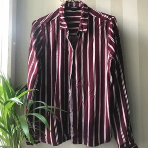 Skjorta från Monki - Vinröd skjorta med ljusrosa och vita ränder, köpt på Monki. Superskön och sitter snyggt på. Storlek S men sitter även bra på XS! 🤍