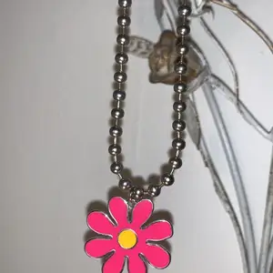 Fin halsband med en rosa blomma på