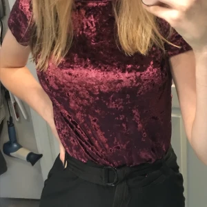 Lila t-shirt i krossad sammet material - En lila t-shirt i krossad sammet material i storlek XS. Bra kvalitet då den är använd en gång. Första bilden så är tröjan instoppad och i andra så är den inte det. Står inte för postens strul. Köparen betalar frakten. Buda i kommentera💞💞