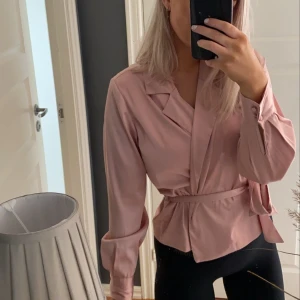 Satin blus - En jättefin rosa färg i en satin blus!!! Antingen har man den så som på bilden eller knyter man upp den om man vill använda den till fest eller liknande😍 så snygg på!! Från bikbok i storlek S, säljer för 150 kr inkl frakten 🤍