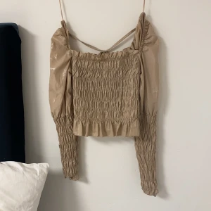 Festtopp ifrån gina - Jättefin guldig festtopp ifrån Gina tricot. Den sitter snyggt och skön att ha på sig. Sista bilden är baksidan då det  är en knytning i ryggen 