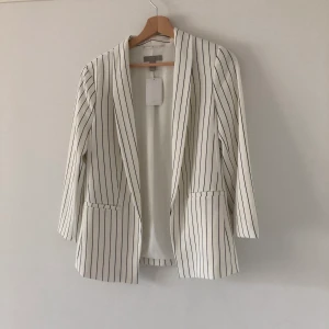 Vit kavaj med blåa ränder  - EJ TILLGÄNGLIG JUST NU Vit, helt oanvänd kavaj med mörkblåa ränder från HM. Prislappen finns kvar. Frakt betalas av köparen. Skriva gärna om du har några frågor✨