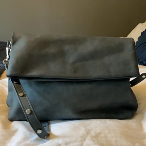 Väska  - Fin väska med två stora fack, i en grå/grön färg med nitar på banden, aldrig använt.