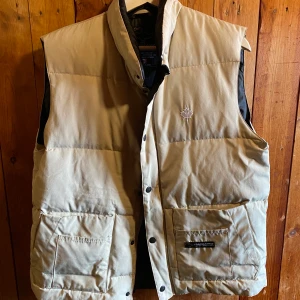 Canada Goose väst, strl Large - Säljer en äkta beige Canada Goose väst. Äkthetsstämpel finns inne i jackan också såklart. Väldigt fint skick. Nästan aldrig använd. Pris kan diskuteras