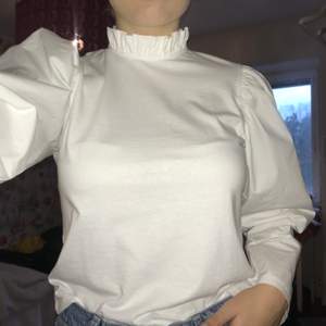 En långärmad tshirt som har en vågad krage och puffiga skjortärmar. Från Zara storlek 36. Fin att ha under en väst🌻