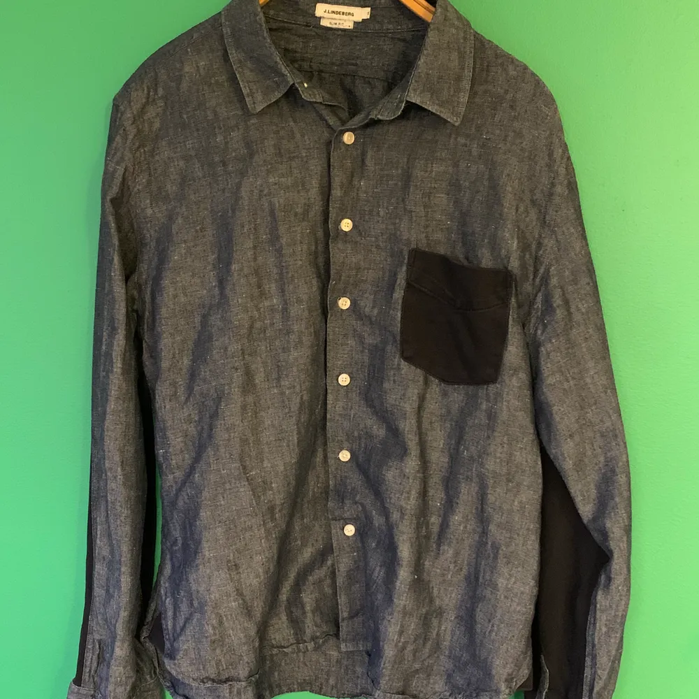 Skjorta från J. Lindeberg i denim med mörkblå detaljer på ficka och armbågar stl XL slim fit (liten i storleken). . Skjortor.