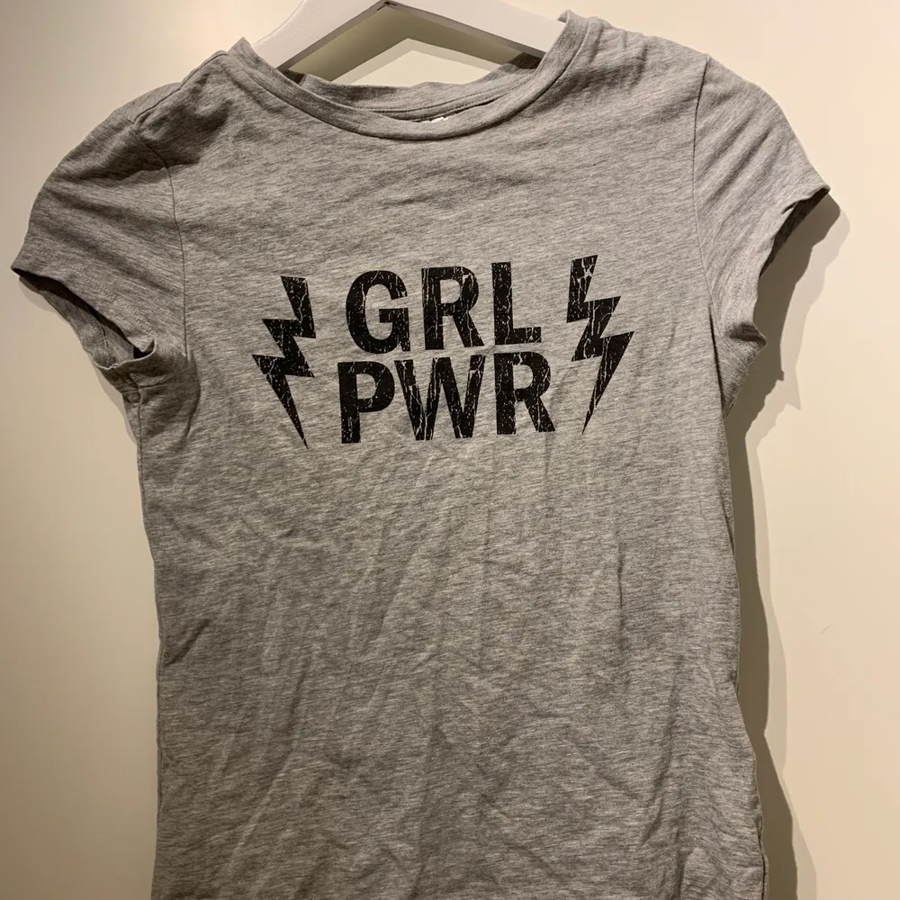 Grå tajt t-shirt med texten ”GRL PWR” på framsidan. Storlek s, men passar även en xs. Köpt på hm. 50kr+ frakt. T-shirts.
