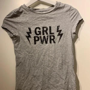 Grå tröja - Grå tajt t-shirt med texten ”GRL PWR” på framsidan. Storlek s, men passar även en xs. Köpt på hm. 50kr+ frakt