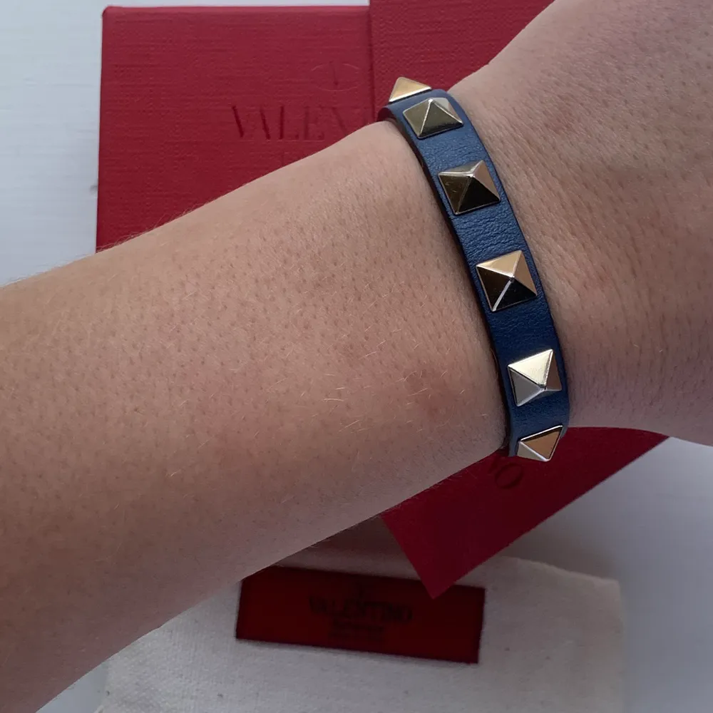 INTRESSEKOLL! Armband från valentino, blått med guldiga nitar. Nyskick, allt på bilden ingår! ☺️ Högsta bud 1700 . Accessoarer.