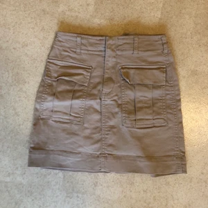Beige kjol - Köper en beige cargo-liknande kjol från GinaTricot. Lagom använd men trots allt i toppenskick, behöver endast strykas lite! Storlek 34