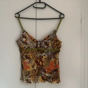 Mönstrad topp - V-ringad möstrad topp från märket pimkie. Står inte storlek, men skulle uppskatta den till en M. Flätade axelband. Något kortare i modellen. Skriv för fler bilder! Bra skick! Budgivning slutar torsdag kväll (12/11) kl 20