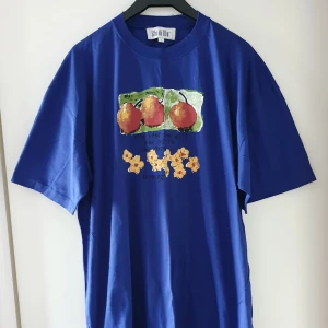 Vintage blå t-shirt med tryck - Vintage blå t-shirt med tryck i storlek L, rätt stor/oversize i storleken. Fraktkostnad blir 45kr. OBS! Budgivning till lördag kl 17. Kommentera jättegärna bud vid intresse (med höjning på minst 5kr, exkl frakt) tack! 😊