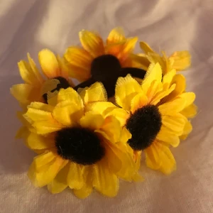 Trendig solrostofs  - Gullig tofs med solrosor på. Töjbar och lätt att använda. Knappt använd. Startbud 5kr (+frakt 11kr). 