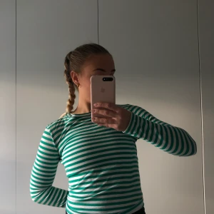 Långärmad tröja - Grönrandig långärmad tröja från na-kd. Tunt och skönt material och sitter som en smäck. Säljer pga använder inte längre.