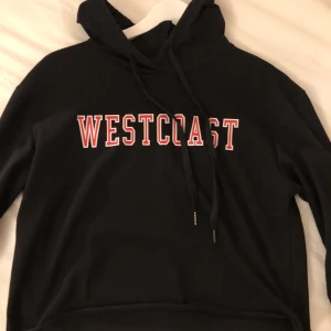 Westcost Hoodie XS - Svart hoodie med texten WESTCOAST i rött med vita kanter. Strl XS croppad.  Knappt använd i nyskick. Säljes pga garderobränsning. 50kr+frakt 
