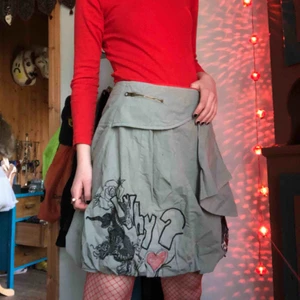  - En grå-grön kjol med vackra, rejäla broderier. Kjolen har även ett spänne som man stänger/öppnar, ungefär där jag har min hand på bild 1. Kan skicka mer detaljbilder om någon är intresserad🧚🏼‍♀️  Möts upp i Gbg, annars står köparen för frakten xoxo