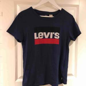 Blå Levis t-skirt med snyggt tryck på framsidan av tröjan. Sparsamt använd, fint skick! 