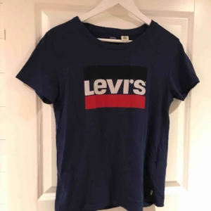  - Blå Levis t-skirt med snyggt tryck på framsidan av tröjan. Sparsamt använd, fint skick! 