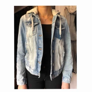  - Blå spräcklig jeans jacka med vissa slitningar, 5 fickor, text på ryggen ( stay magical ) med luva.  Nästa aldrig använd 