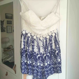  - Helt oanvänd jumpsuit från Xenia i Australien. Vit/blå-blommig med vit spets upptill. Nypris ca 400 kr. Hämtas i Malmö alt. står köparen för frakt. Fler bilder: https://www.xeniaboutique.com.au/collections/playsuits/products/jasmine-playsuit-1
