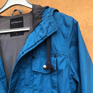  - Trevligt skick. Med luva. Perfekt vår/sommarkvälls-jacka. Vattenavstötande material 