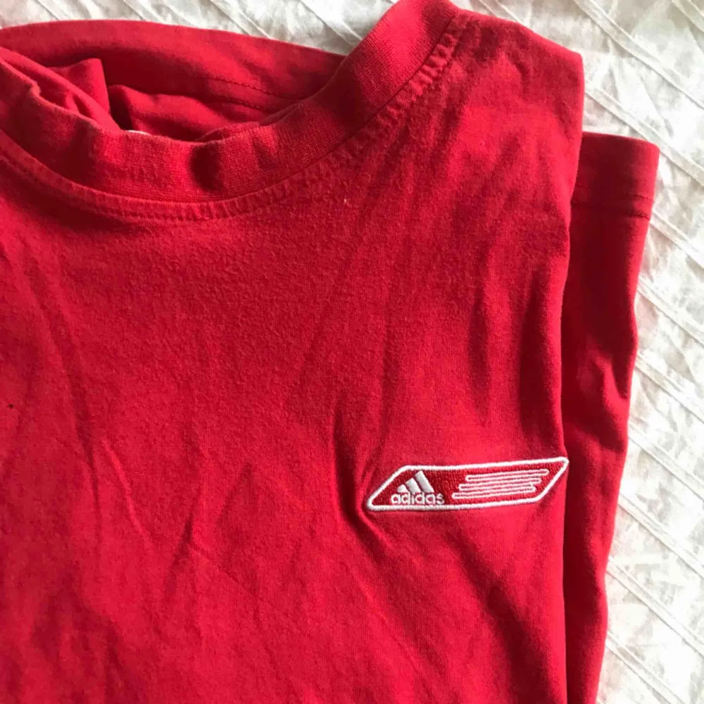 Röd adidas t-shirt. Står ej storlek men jag skulle säga att det är en M/L. Jag är en S och den sitter oversize på mig. Köparen står för frakt. T-shirts.