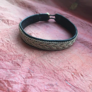  - Tennkonstarmband med svart läder på insidan. Knapp i renhorn.  Minns ej var armbandet är inköpt.