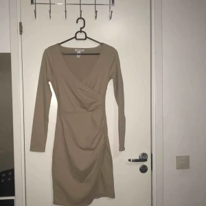  - En fin tajt beige klänning från Nelly, oanvänd! Frakten står du för själv :) (Betalning via swish)  