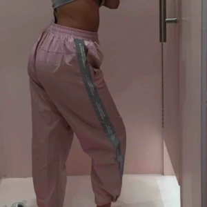  - Suuupersnygga rosa trackpants från sorella. Använda en gång, nypris 800 kr. Grå reflex längs sidorna samt knyte på insida av byxremen. Supersköna