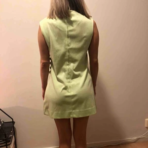  - 70tals klänning i mint/ljusgrön. Har en slits på sidan som går rätt högt upp. 