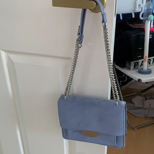 Blå väska  - Ljusblå väska från hm i mockaimitation. Använd 2 gånger, ser ut som ny. Går att använda som crossbody eller vanlig axelväska. Har 3 fack inuti. Köpt för 300kr.  Fler bilder lämnas på begäran. 