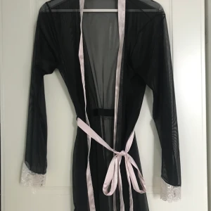 Kimono - Genomskinlig kimono med spets och stenar längst ut på armarna. Aldrig använd