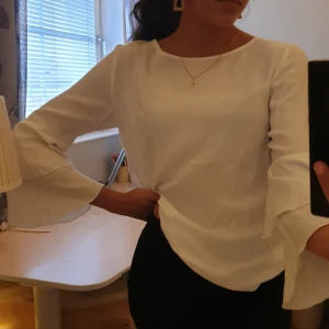 Vit blus med volanger - Super fin och använd endast ett fåtal gånger, man kan styla den på olika sätt men jag gillar att antigen låta den bara hänga eller stoppa in den under behån, 100% viskos strl xs/s 💘