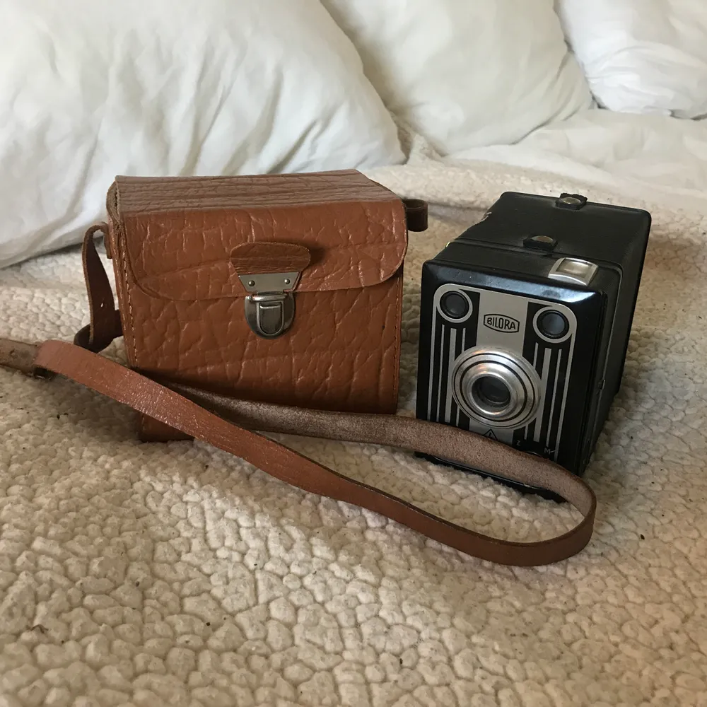 Jättefin gamal liten kameraväska med en icke-fungerande kamera som medföljer.  Gjord i brunt läder, justerbart axelband. En får plats med minst två medelstora äpplen i.. Väskor.