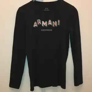 Svart långärmad tröja från Armani! Texten är delvis med paljetter också💃🏻 tröjan är i storlek M, tröjan är använd några gånger men i bra skick!! 