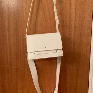 Vit Carin Wester väska - Vit väska från Carin Wester! Två band; ett axelremsband och en midjeband (se bild 2). Har 3 fack; två lite större och ett mindre. Kan skicka fler bilder. Köparen står för frakt, 59kr. Kan även mötas i gbgområdet. Betalning via Swish.